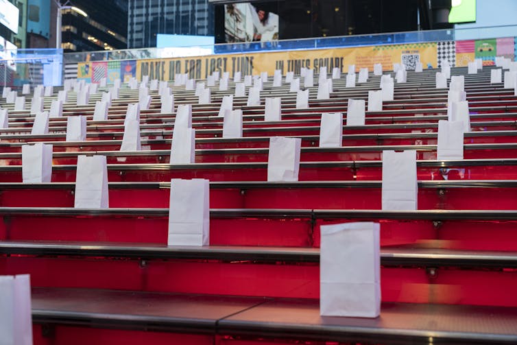 Dozens of white bags are placed on red stairs.