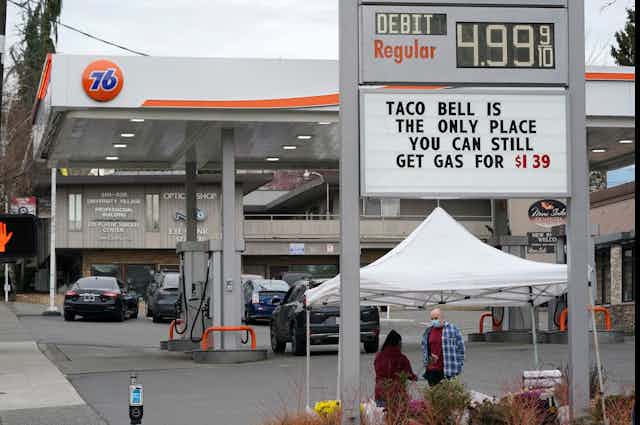 Signboard with a joke about gasoline prices below a curent price of $4.99 per gallon for regular