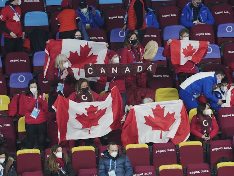 A crowd of spectators holding Canadian flags