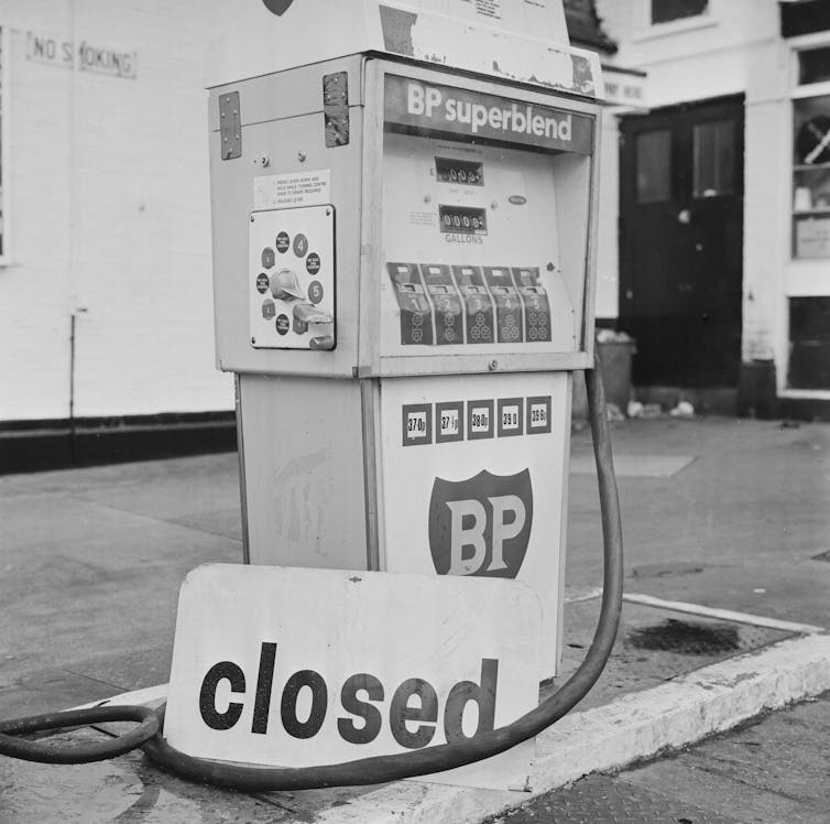 black and white image of a petrol pump with a closed sign
