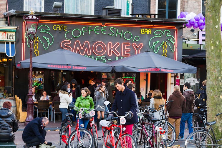 A crowd of people standing outside a coffee shop