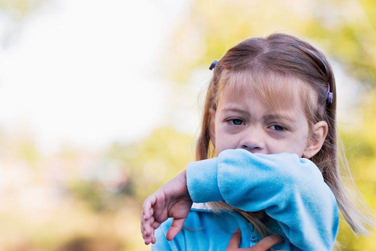 Child coughs into her arm