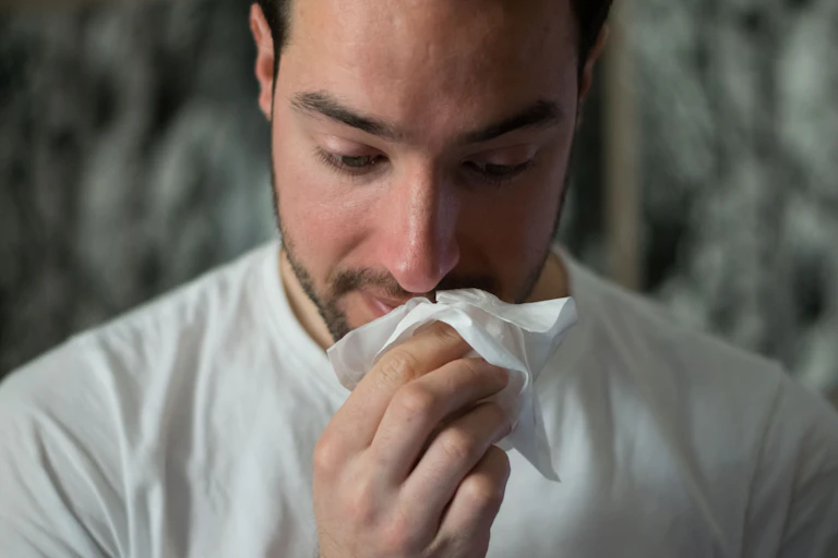 Man puts tissue to his nose