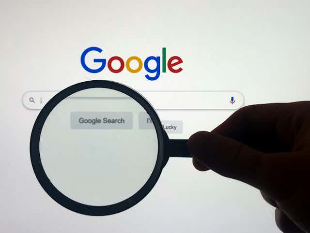 Google homepage with magnifying glass in front of it