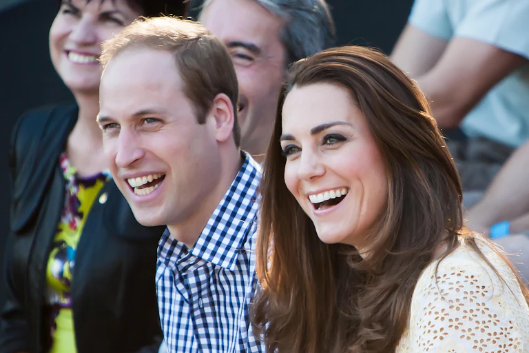 The Duke and Duchess of Cambridge smile while looking away from the camera