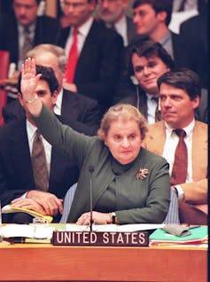 Madeleine Albright raises her arm in a vote at the United Nations
