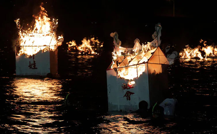 Paper houses burn on lake.