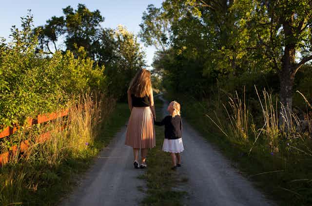 Mother and daughter walking down a path