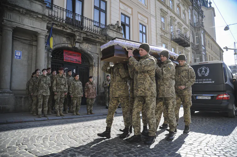 Ukrainian servicemen carry a coffin during a funeral ceremony.