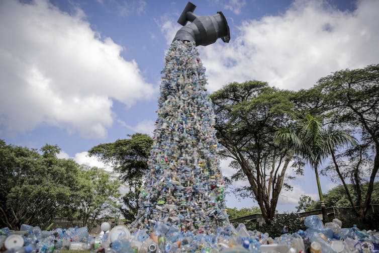 A giant art sculpture showing a tap outpouring plastic bottles.