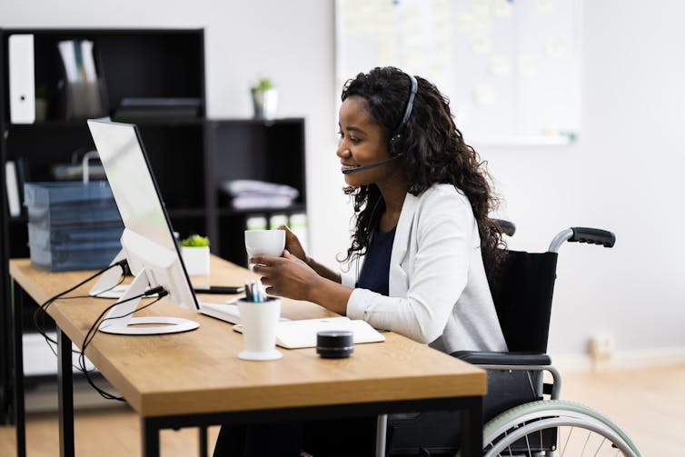 A person working at a computer in a wheelchair.
