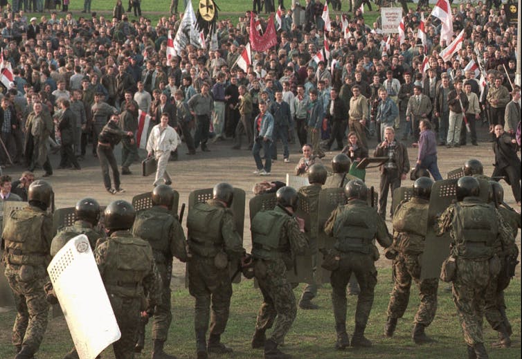 Protesters through stones at armoured police officers.