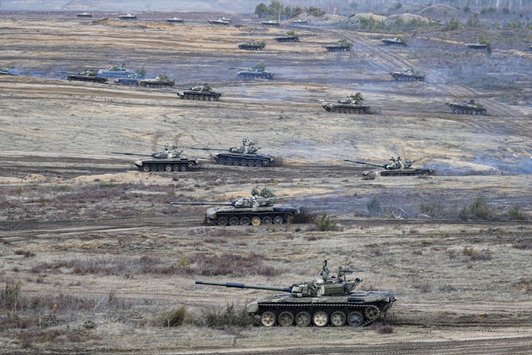 Tanks move in a field.