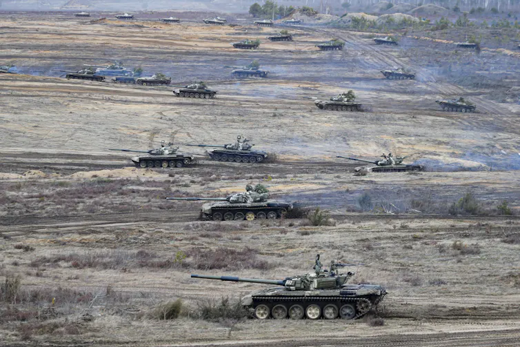 Tanks move in a field.