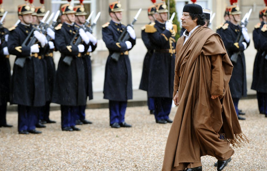 A man on a dress robe inspecting a guard of honour