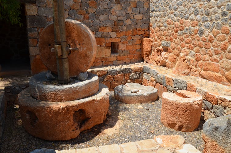 Stones used to crush and press olives to make oil in the ruins of a building