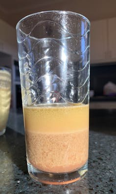 A glass with layers of different coloured liquids inside