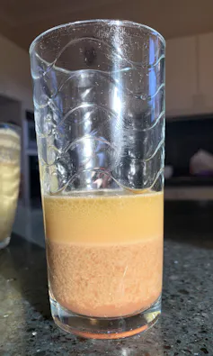 A glass with layers of different coloured liquids inside
