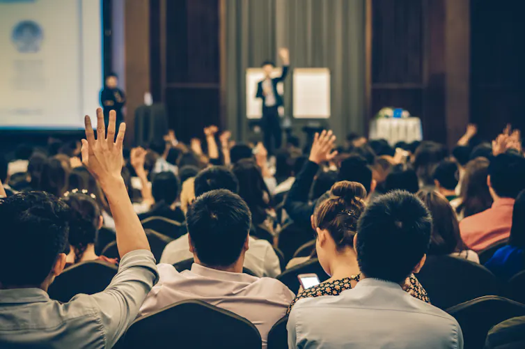 Conférencier sur scène avec vue arrière du public dans la salle de conférence