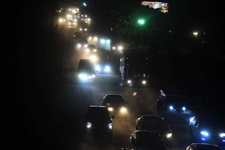 Cars with their headlamps on at night.