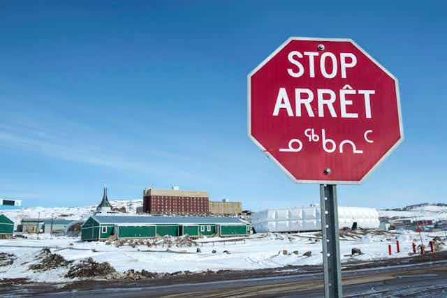 A stop sign in English, French and Inuktut