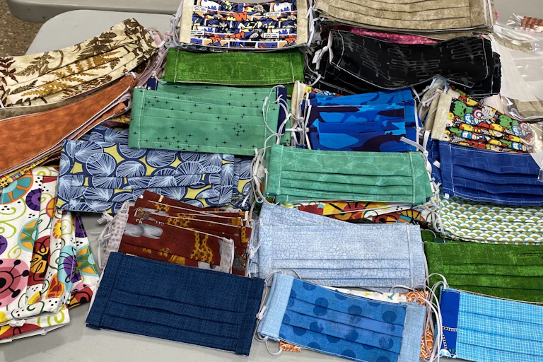 Stacks of fabric face masks in several colours and designs