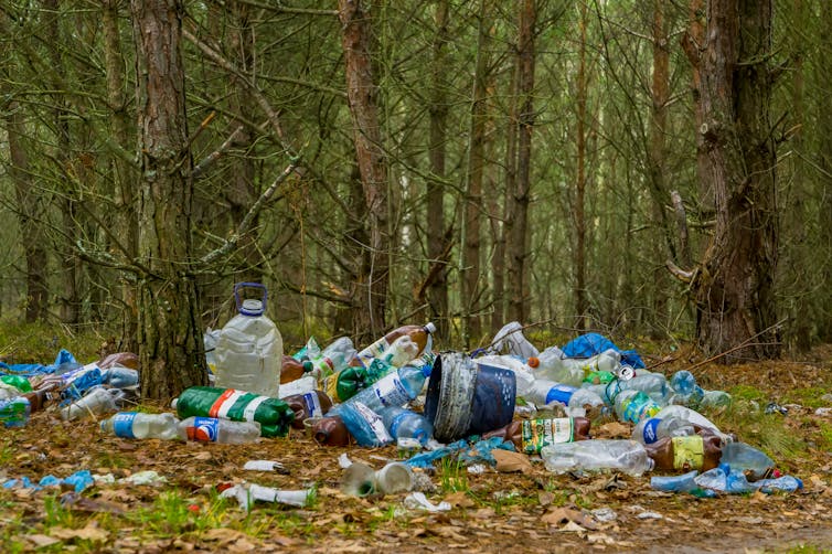 A pile of plastic waste littered in a forest area.