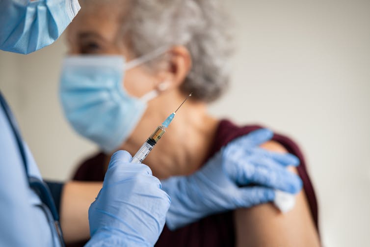 Une dame âgée se fait vacciner