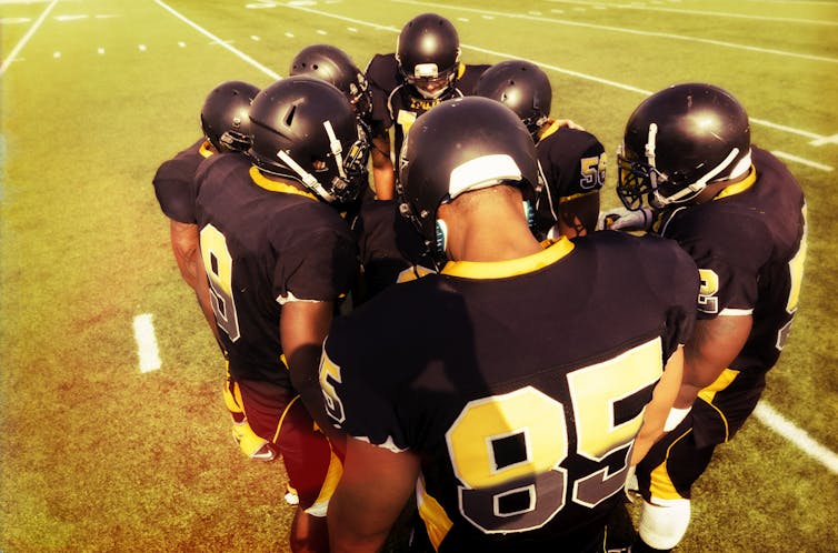 Football players meet in a huddle