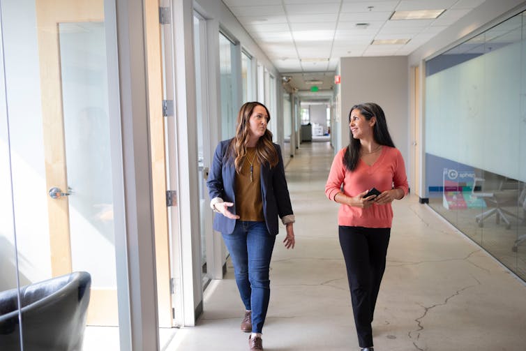 Two women in business attire walking