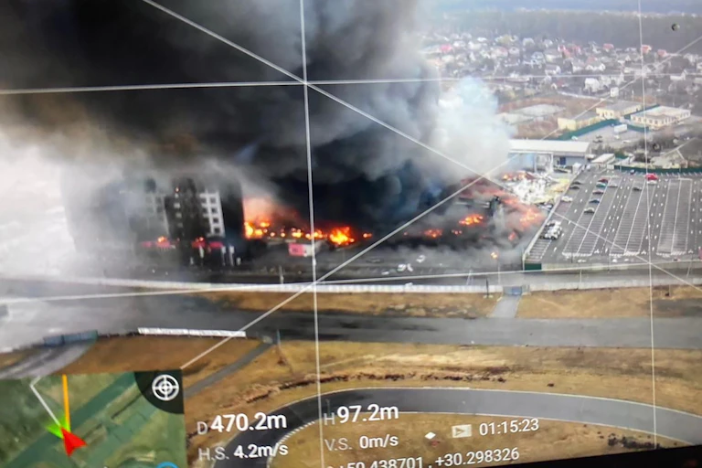 An aerial view of a burning buildings overlaid with drone screen markings