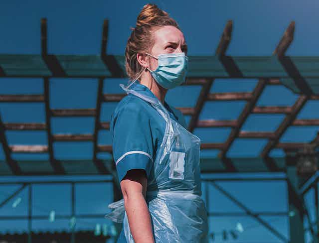 Nurse stands outside in PPE