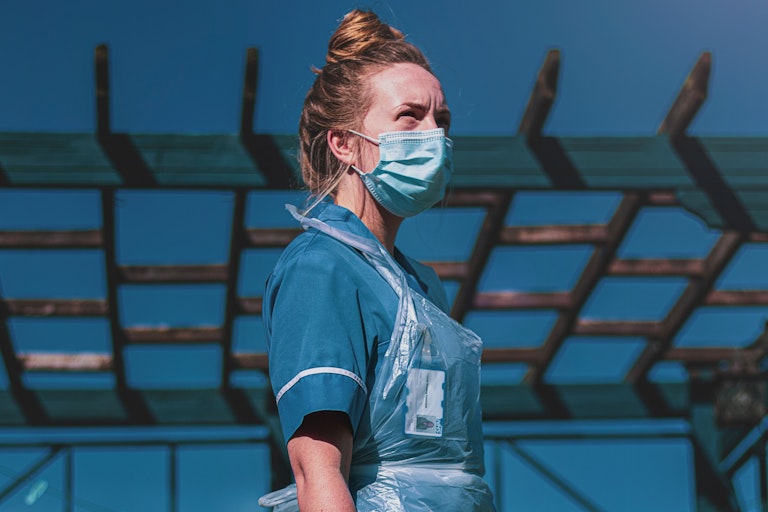 Nurse stands outside in PPE