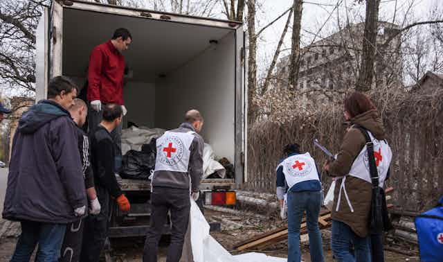 International Committee of the Red Cross (ICRC) workers prepare bags with bodies