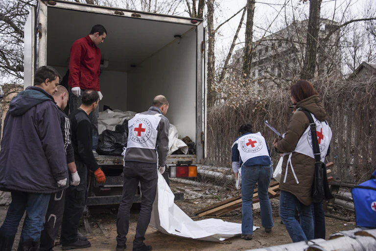 International Committee of the Red Cross (ICRC) workers prepare bags with bodies