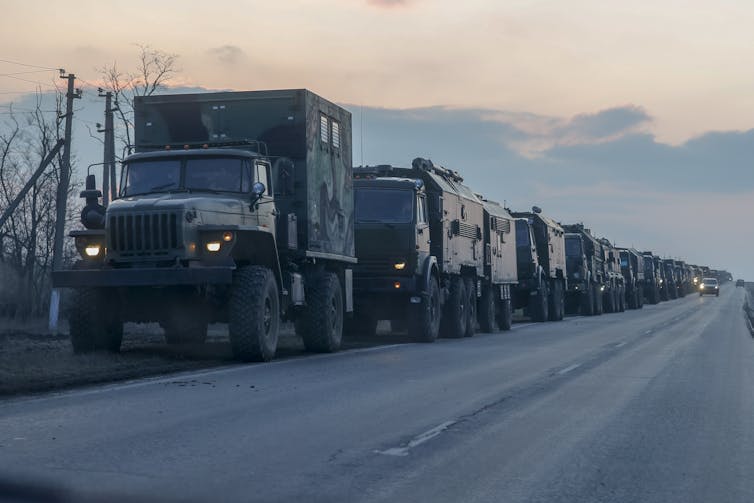 Dozens of trucks with Russian military supplies are seen on a highway.