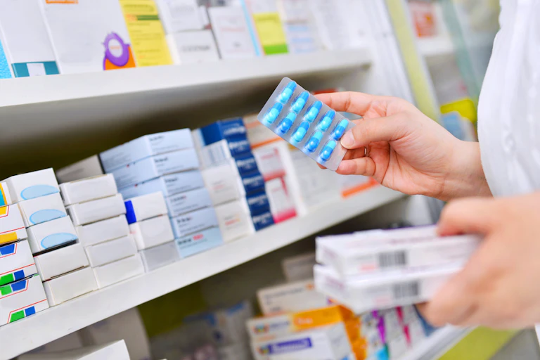 Pharmacist taking medicines off shelf