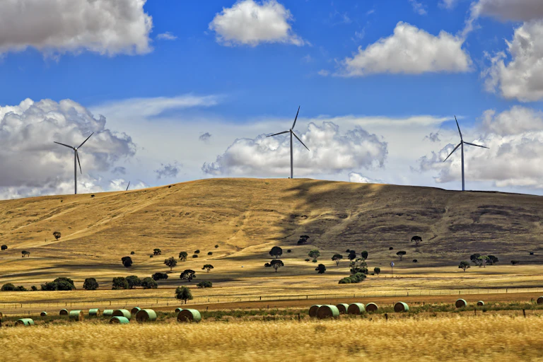 Three wind turbines on a brown hill