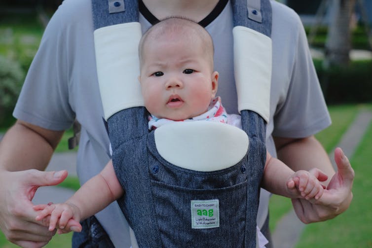 Father with baby in baby carrier.