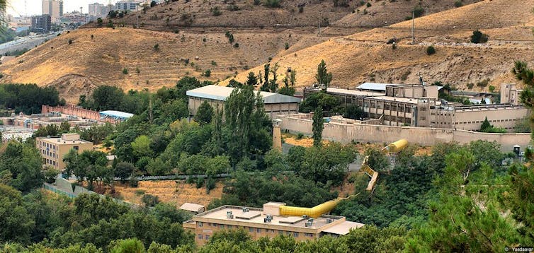 A cluster of prison buildings on a remote hill.