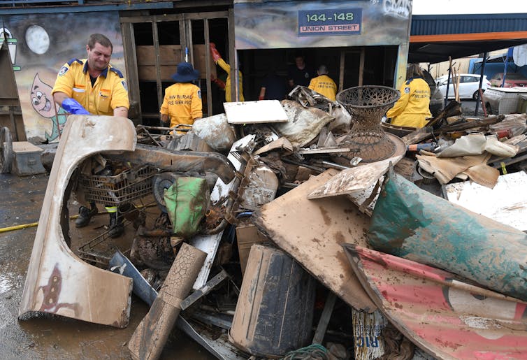 People piling up flood-damaged items