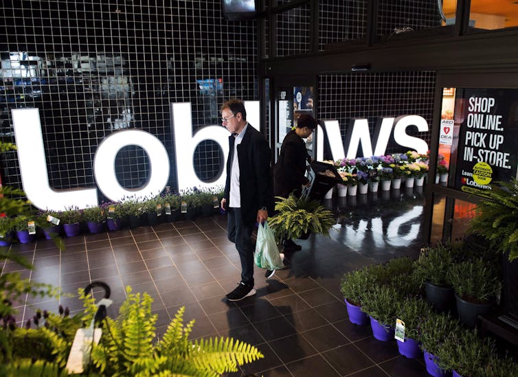 A man walking out of a Loblaws grocery store