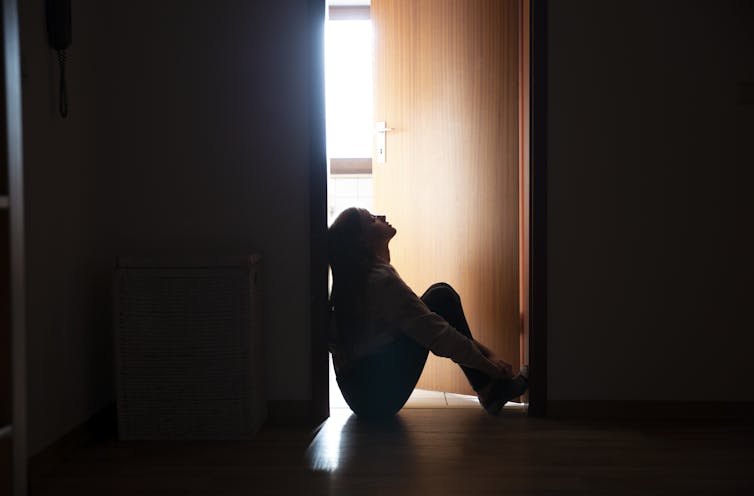 woman sitting on floor in door frame