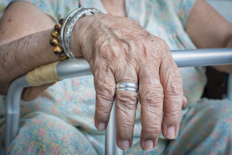 Elderly woman's hand resting on walking frame