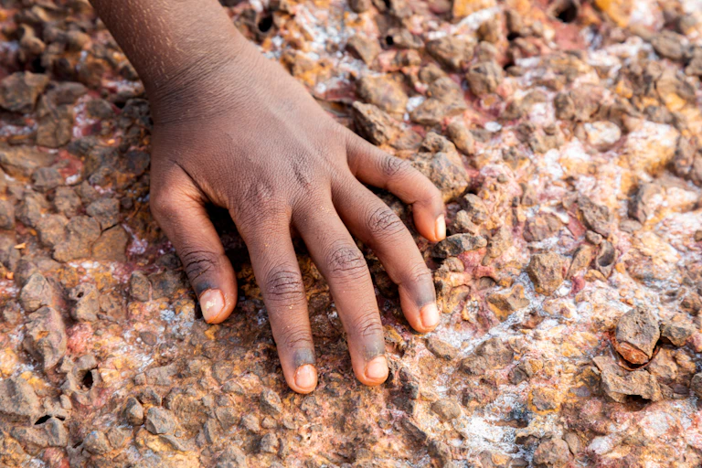 Hand resting on rocks and stones