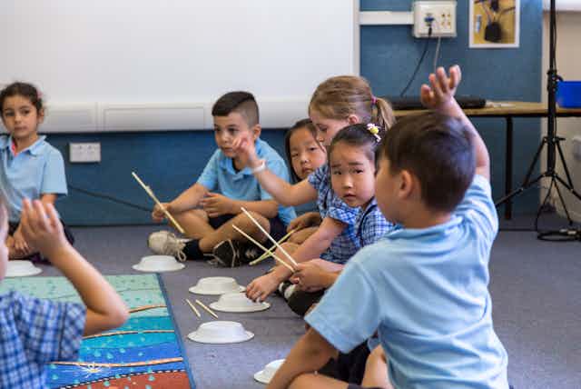Children using paper bowls as drums