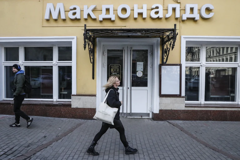 Pedestrians outside a closed restaurant.