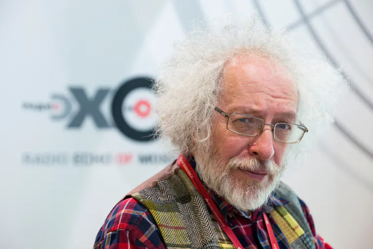 Alexey Venediktov with white hair and glasses looking towards the camera