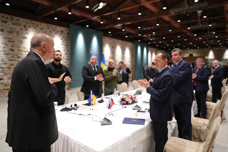 Group of men applaud man at the head of a long table
