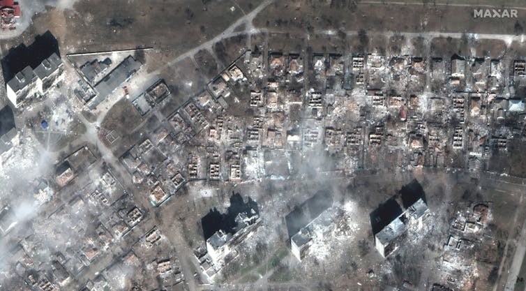 Birds eye view of damaged houses and apartment blocks.